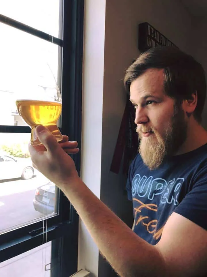 James inspecting a glass of beer in the light
