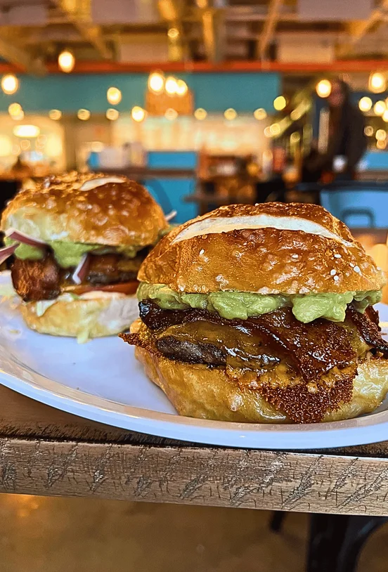 Two Pub Burgers on a plate next to each other