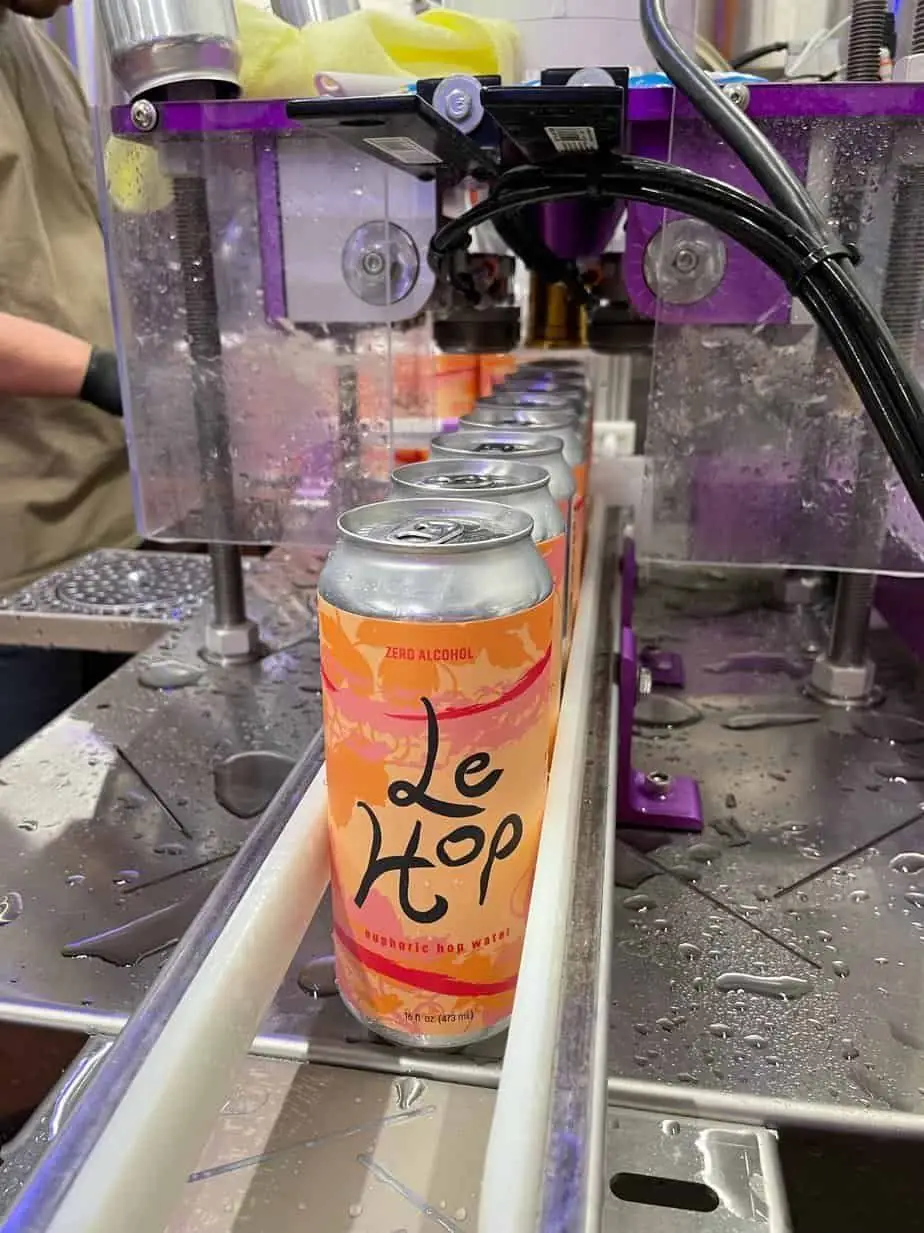 Photo of cans of Le Hop hop water on a canning line. 