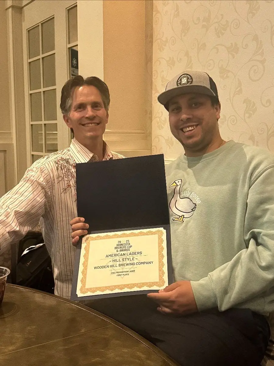 Picture of Jeremy and Montana showcasing the award certificate for our beer, Hill Style, winning Best American Lager.