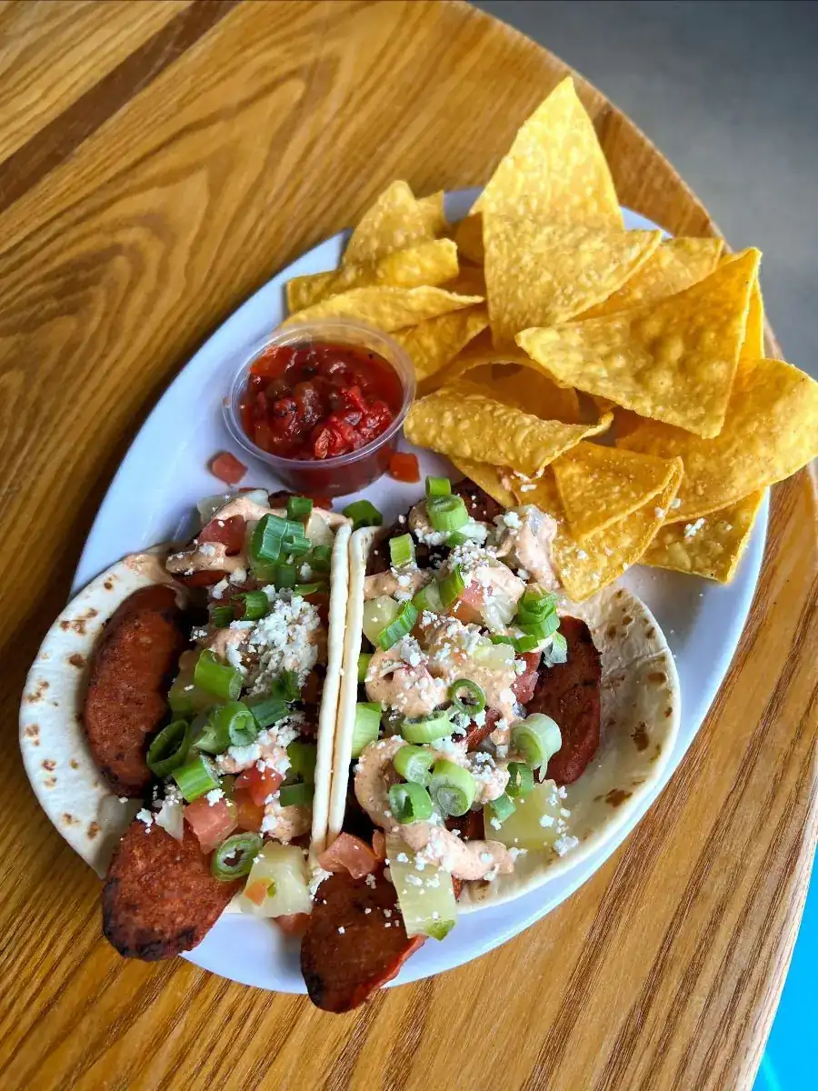 Picture of our Taco Wednesday special - Cajun Andouille Tacos! Picture shows tacos served with chips and salsa.