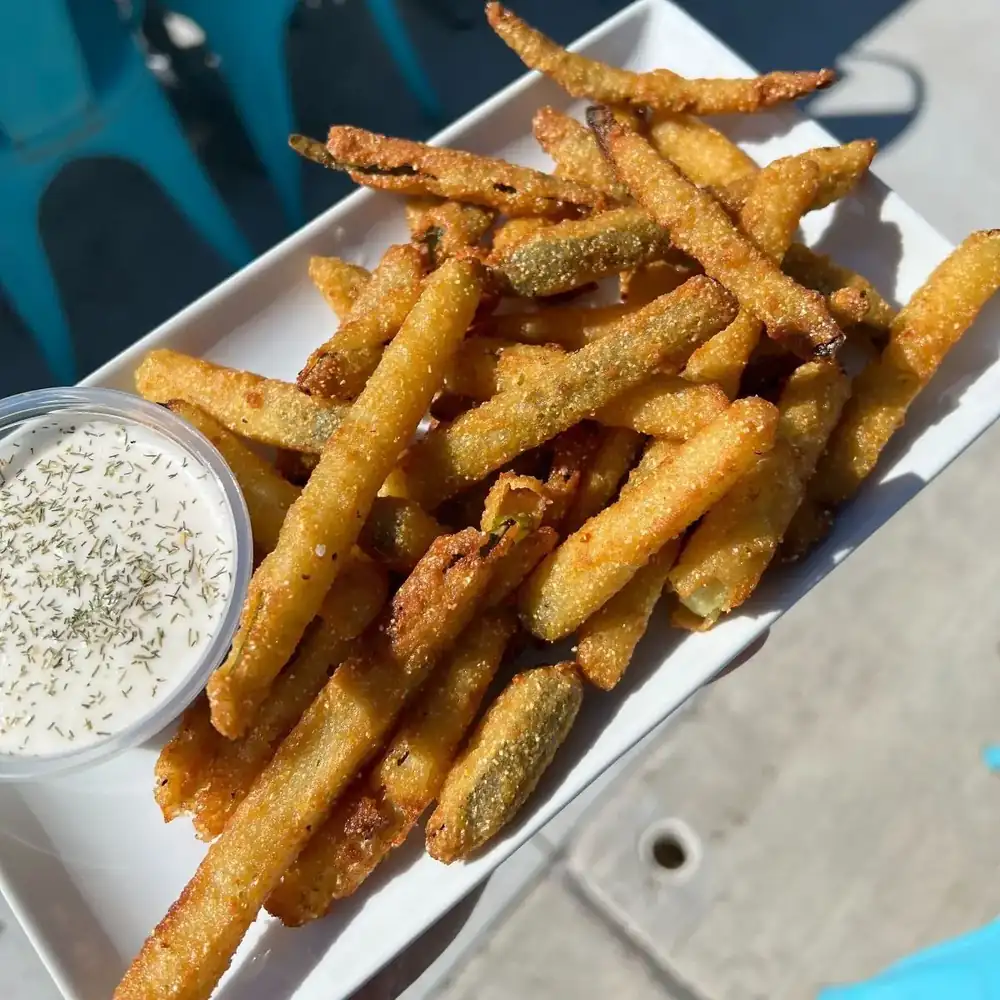 Picture of our pickle fries with a side of ranch dressing.