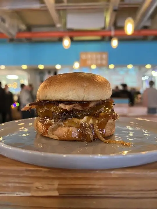 photo of bourbon burger on a plate on a table in wooden hill brewings taproom