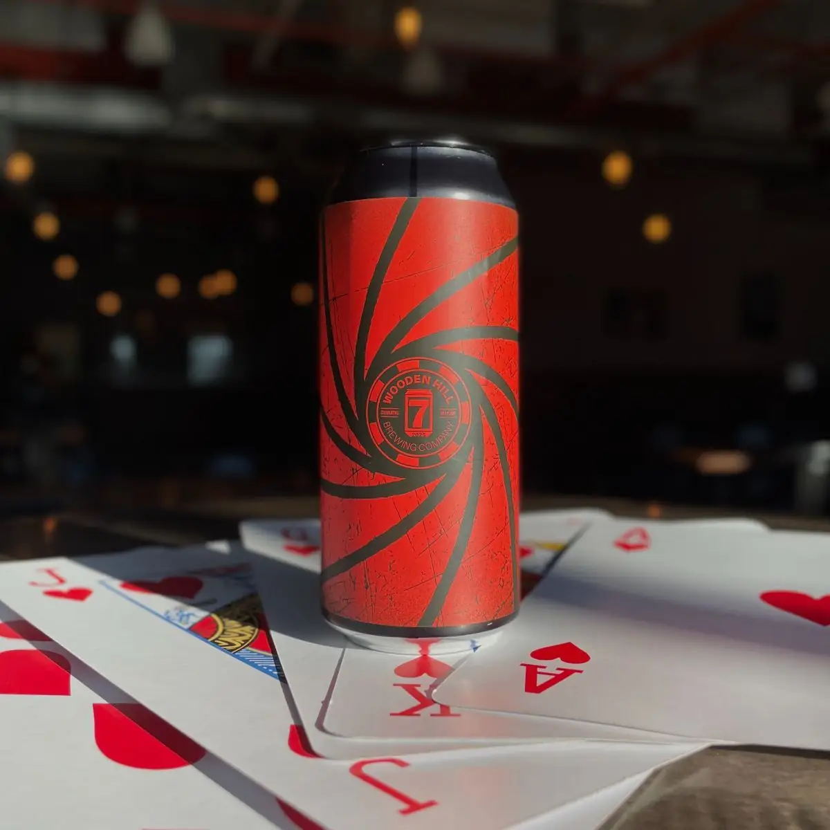 photo of red and black can with Wooden Hill 007 logo. can is on a giant deck of cards