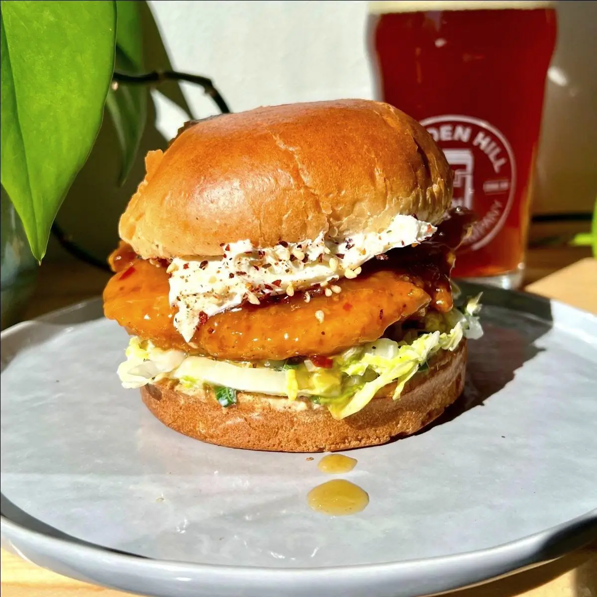 Picture of our new Orange Chicken Sandwich with a beer in the back!