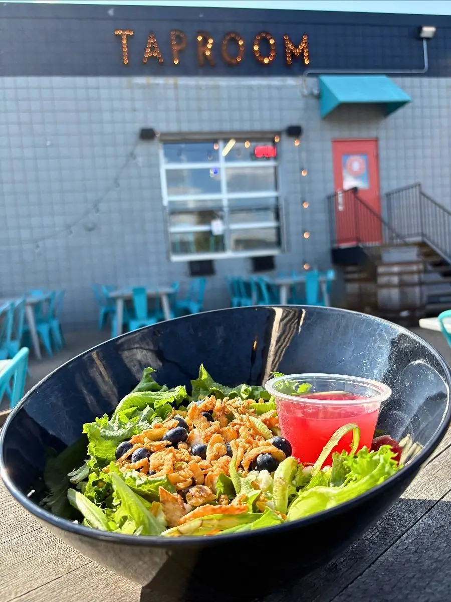 Image of our new mint berry salad taken on the back patio with the brewery and taproom sign in the background.