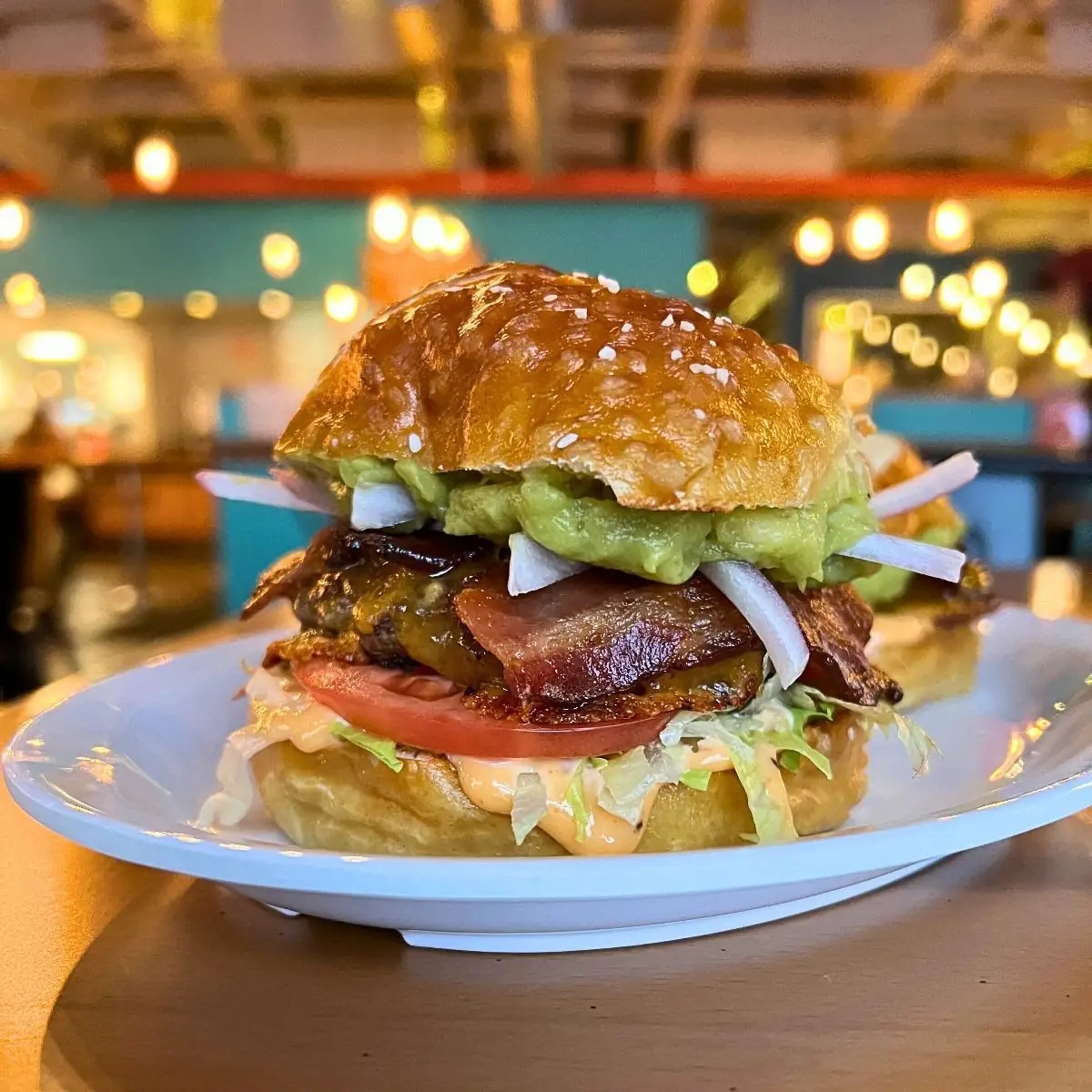 Image of a pub burger on a plate showing all the layers. Background is of the brewery. 
