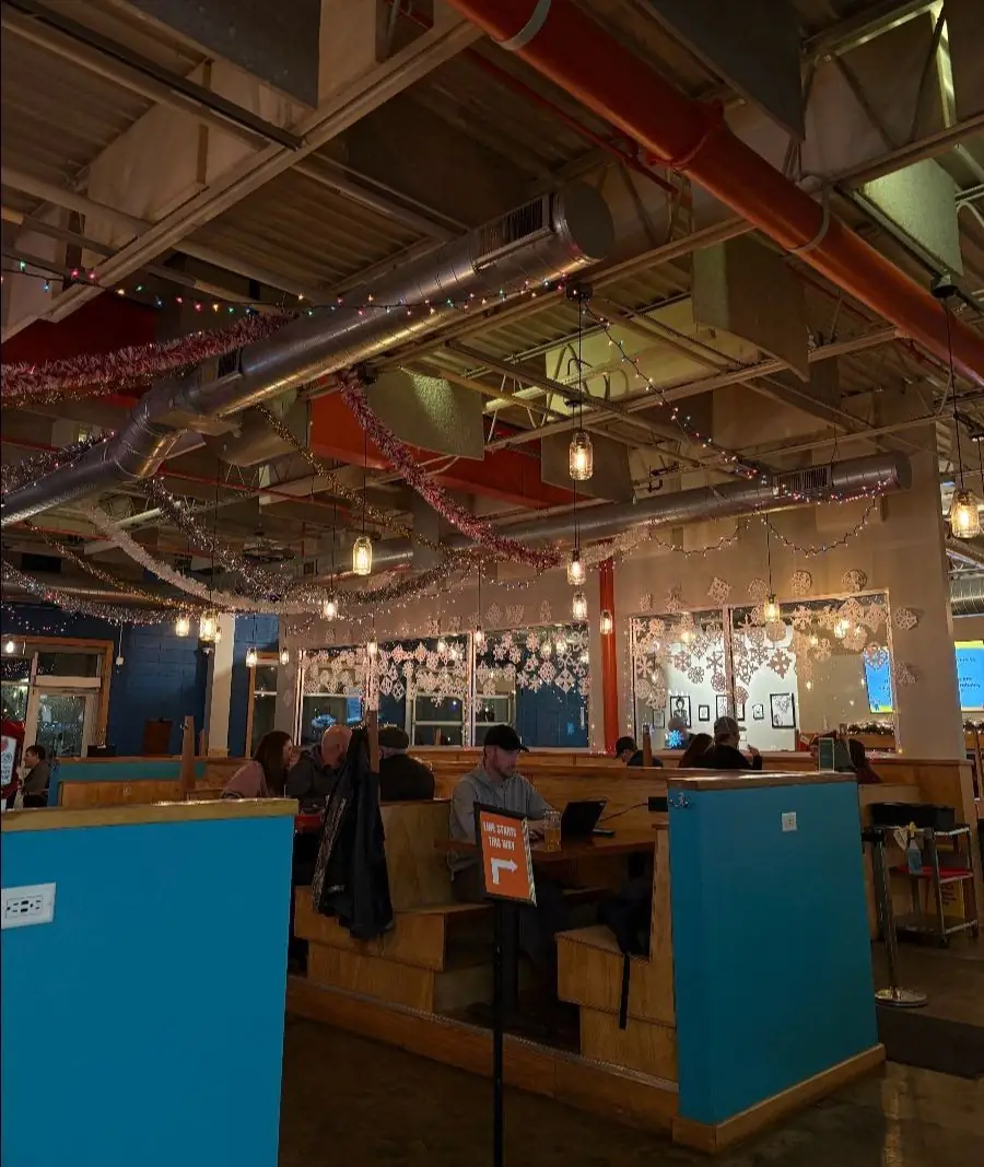 Picture of our front taproom, showing off our jingle bar decorations. Tinsel hanging from the ceiling and paper snowflakes on the windows.