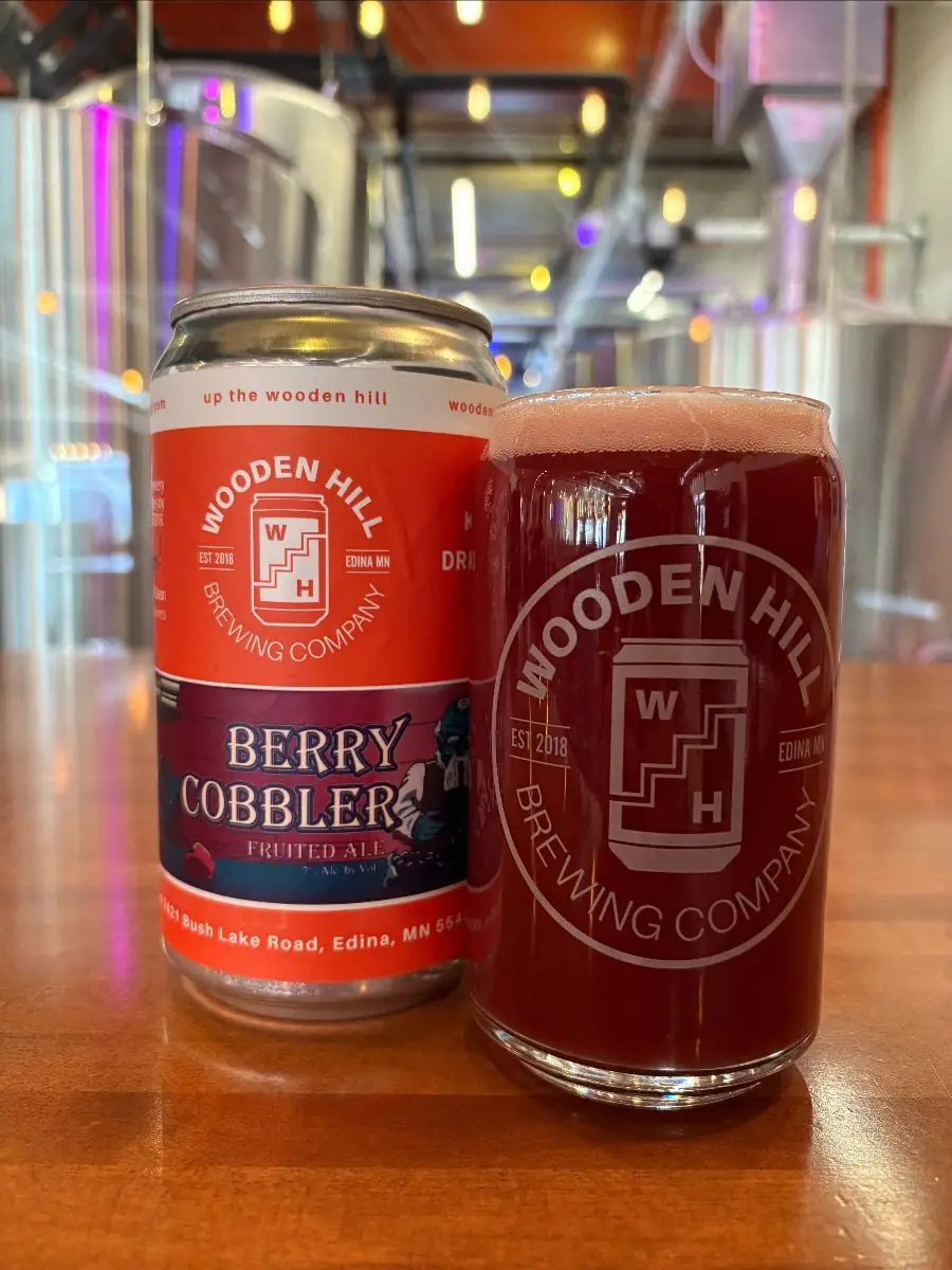 Image of Wooden Hill can of Berry Cobbler on the left and a Wooden Hill glass on the left with a berry colored beer in it.