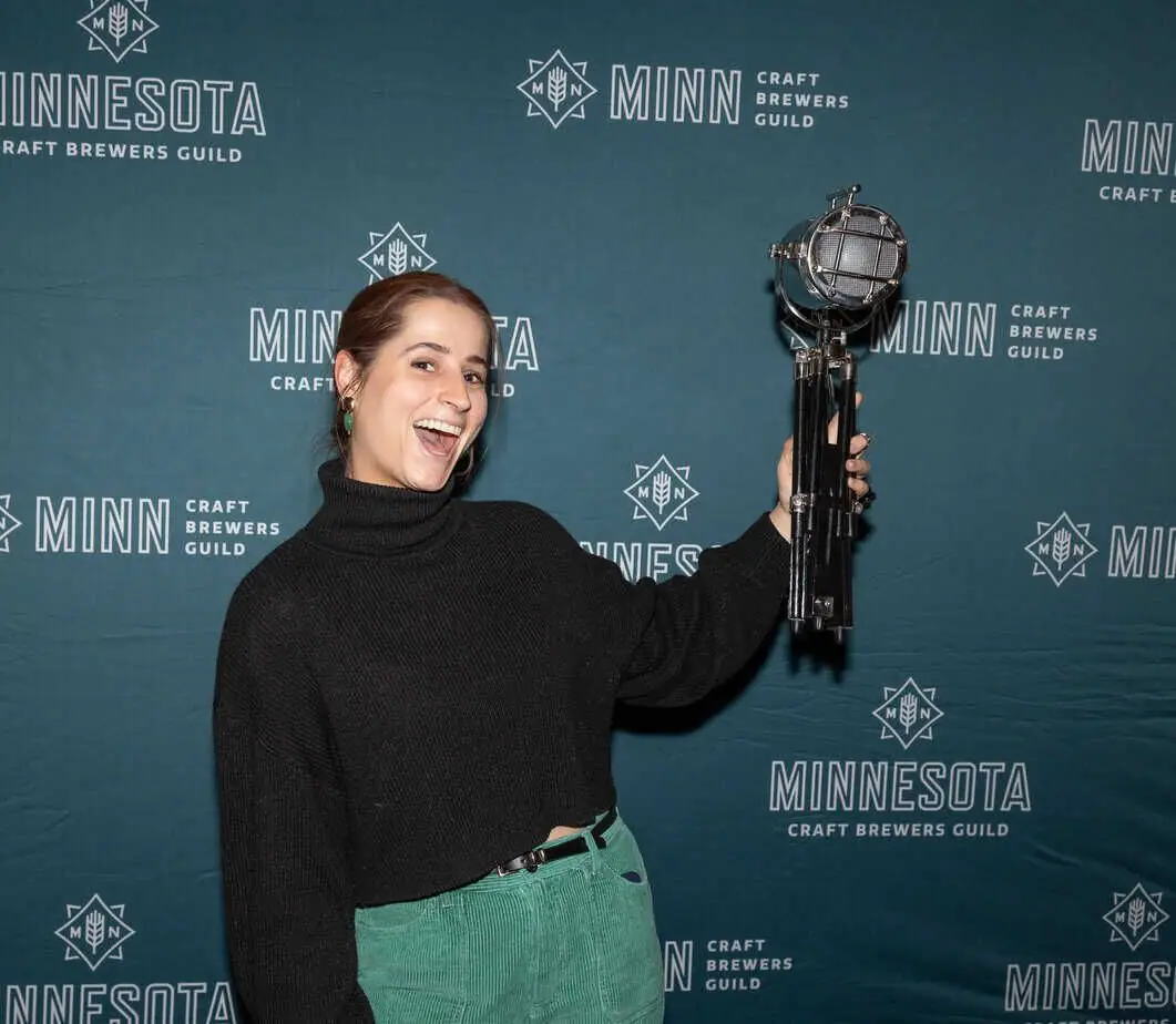 Photograph of graphic designer Mia with the Aluminate award for best can design.