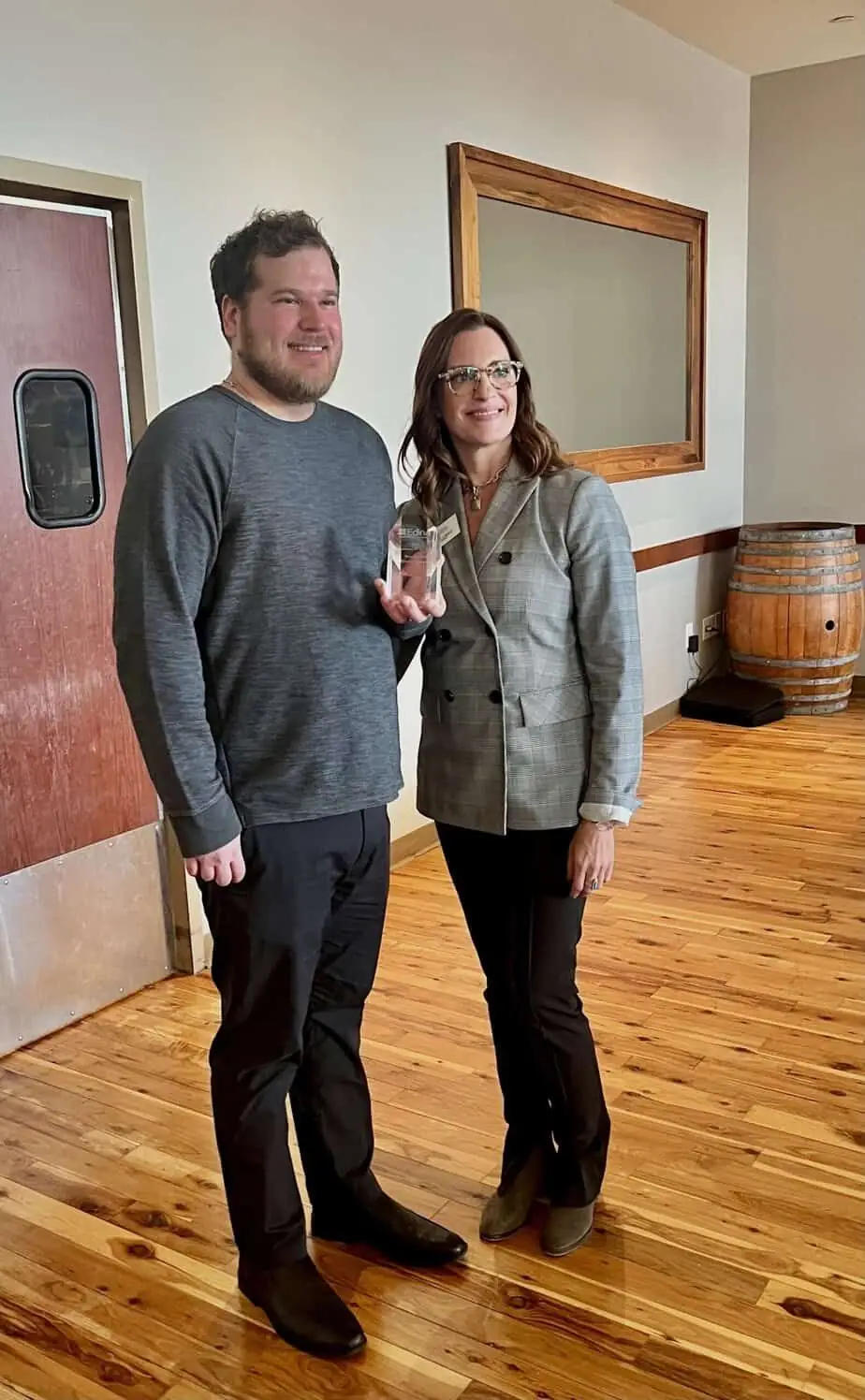 Photograph of Co-Founder James Ewen holding the Business of the Year award with Chamber Director Shelly Loberg.