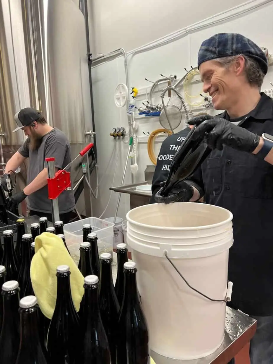A photo of head brewer James and assistant brewer Jeremy bottling beer.